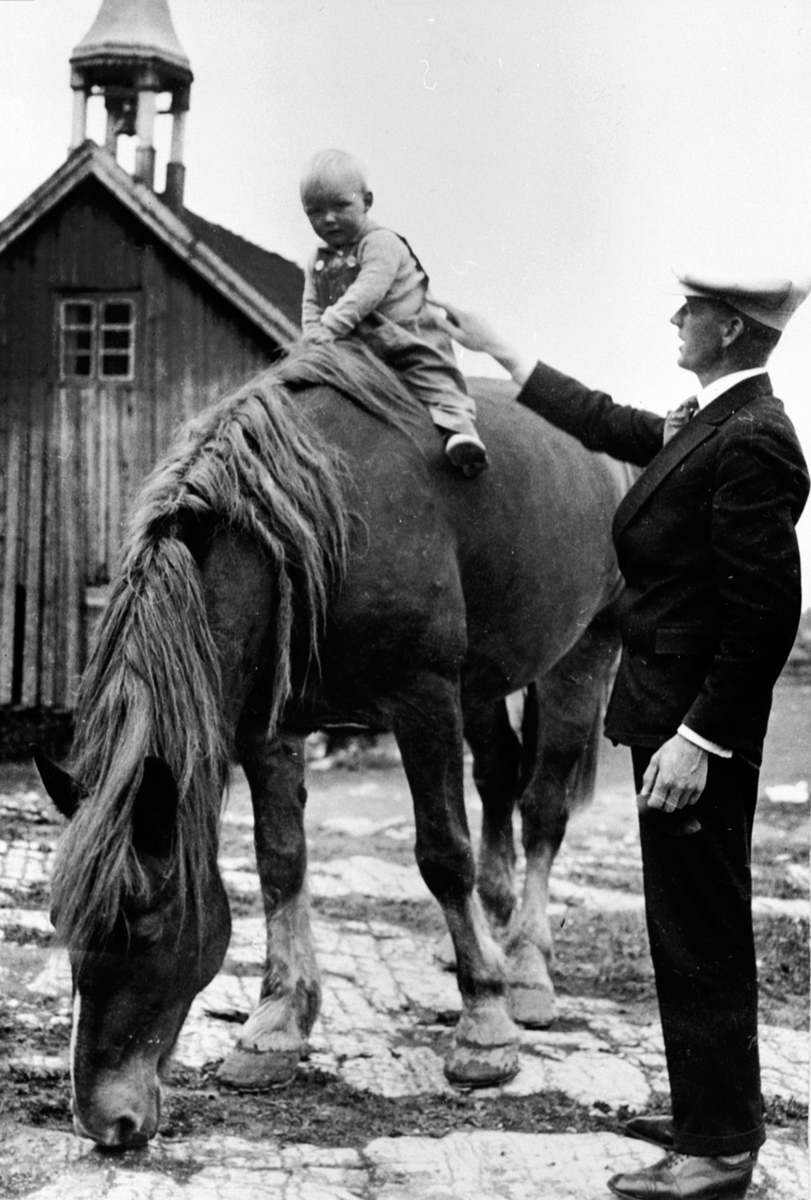 Anno Domkirkeodden, Skinstad gård, Nes Hedmark. Reidar Arthur Brinck 1900-1988, sønnen Bjørn Brinck 1931-1964 på hesteryggen. Stabburet i bakgrunnen er revet.