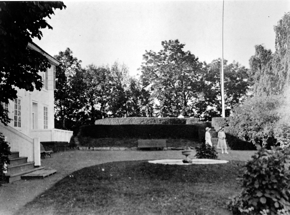 Anno Domkirkeodden, 2 damer med hatt i hagen på Hovinsholm, Helgøya. Fontene.