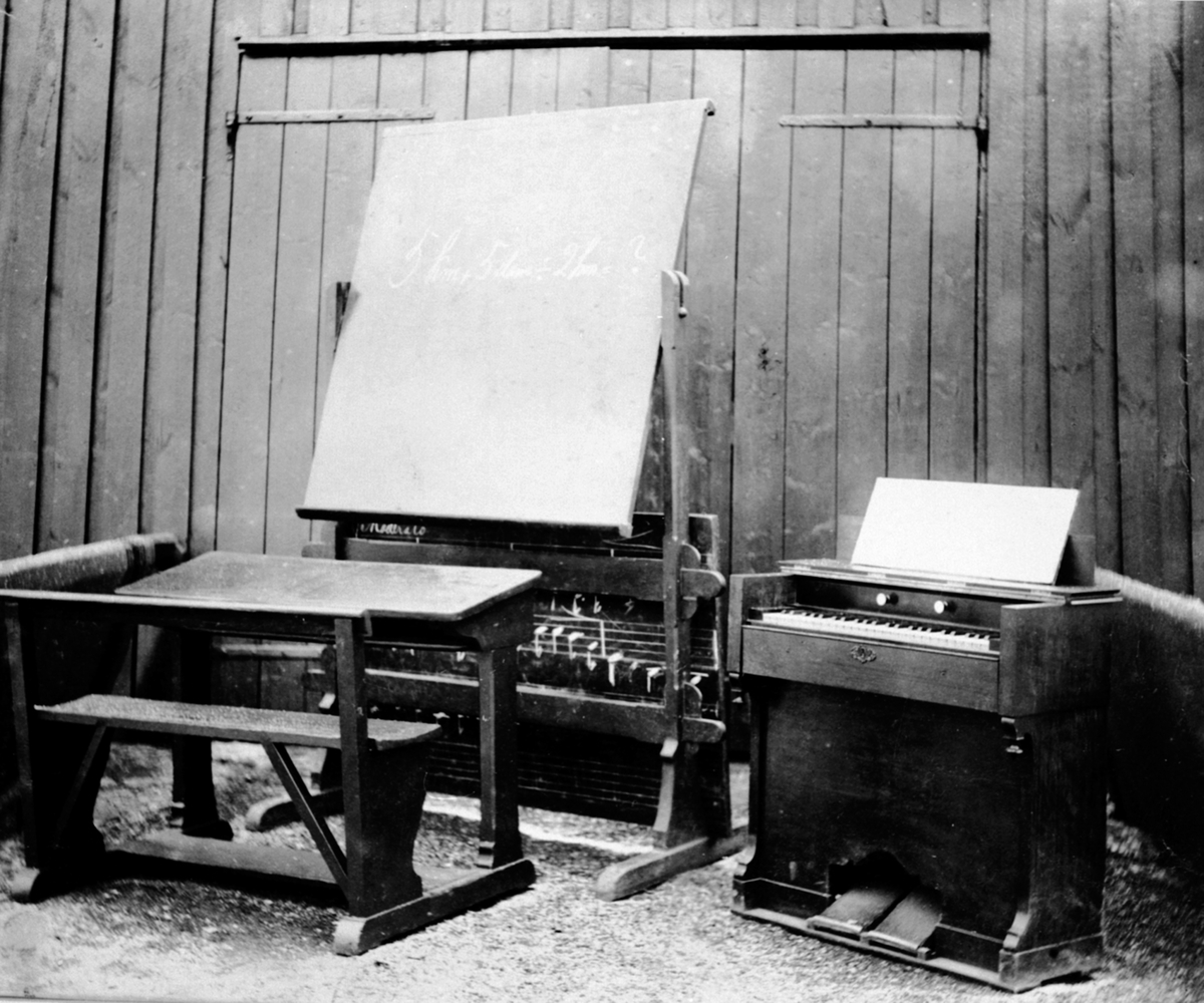 Anno Domkirkeodden, Klasserom for musikkundervisning på Toftes Gave, Nedre Sund, Helgøya med tavle, pult og orgel.