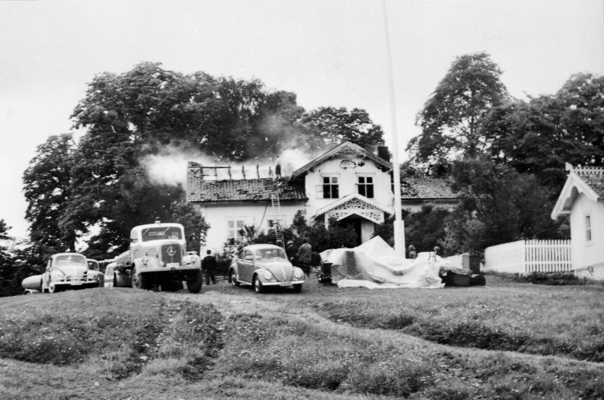 Anno Domkirkeodden, Brann i føderådsbygningen på Vinju gård, Ringsaker. brannbil, Mercedes-Benz, reg.nr. på brannbil var D-74678, 1954-modell. slukningsarbeid, mye folk. Personbiler VW. Volkswagen, folkevogn.