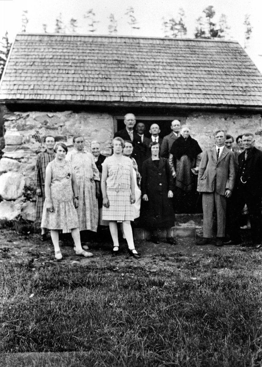 Anno Domkirkeodden, Gruppe personer utenfor steinfjøset i Atfor. Fest for arbeiderne på Hovelsrud, Helgøya. Foran fra venstre er Tea Maurud, Kirsten Slåtten, Albertine Engeland, Mina Kval, Marie Martinsen, frk. Signe Sæthern, Martha Solbakken, Kristine Kval, Harald Helmersen, Tomas Solbakken, Marianne Olssøn, Adolf En…