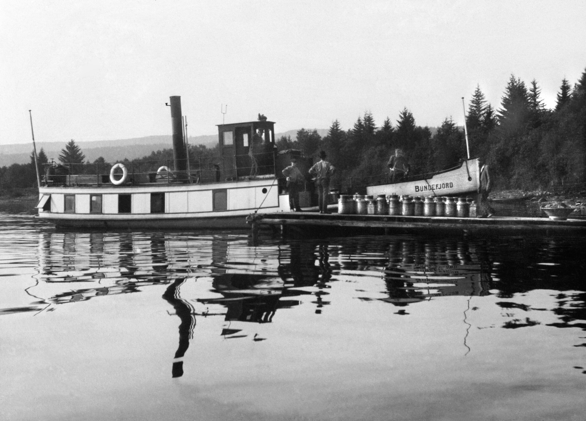 Anno Domkirkeodden, Båten "Bundefjord" i Nerlivika. Laster melkespann ved brygga i Nerlien, Nes, Hedmark. Båten het tidligere "D.S. Prøven".