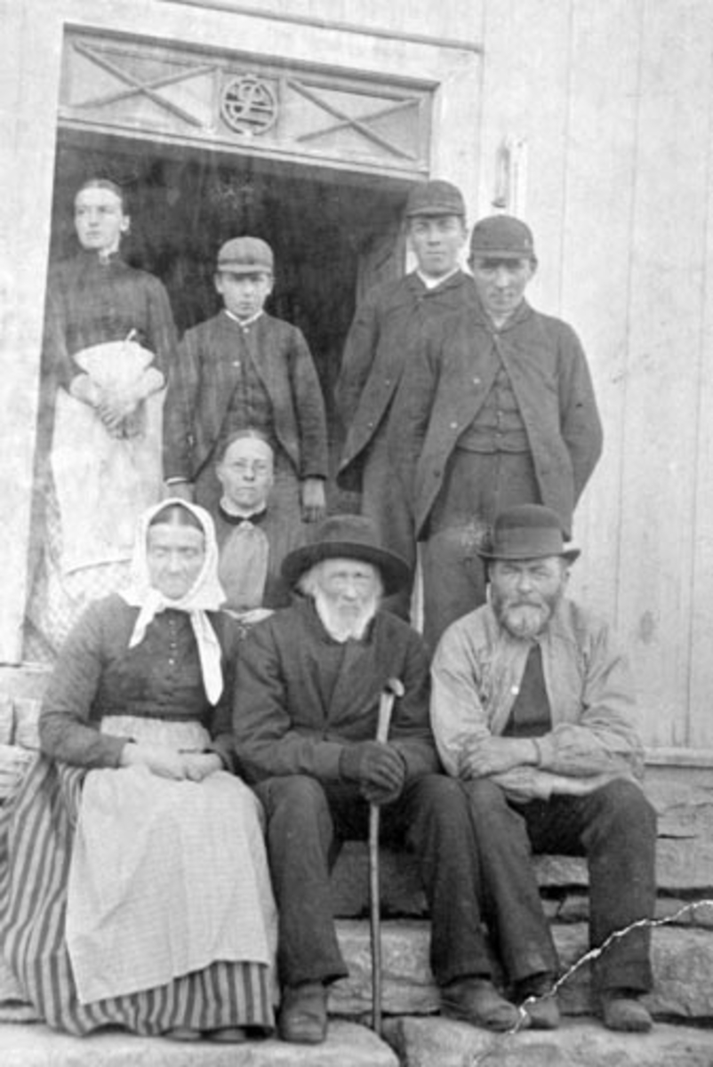 Anno Domkirkeodden, Peder Olsen Gjøvik/Gaalaas (1810-1892) foran inngagsdøra, sittende mellom sønnen Ole Pedersen Gaalaas (1836-1918) og svigerdatter Elisabeth Andersdatter Kvam (1836-1918). Sittende bak dem er Lise Pedersdatter Gaalaas f. 1847. Stående bak er fra venstre Kristiane (1864-1927), Torger f.1876, Anders f…