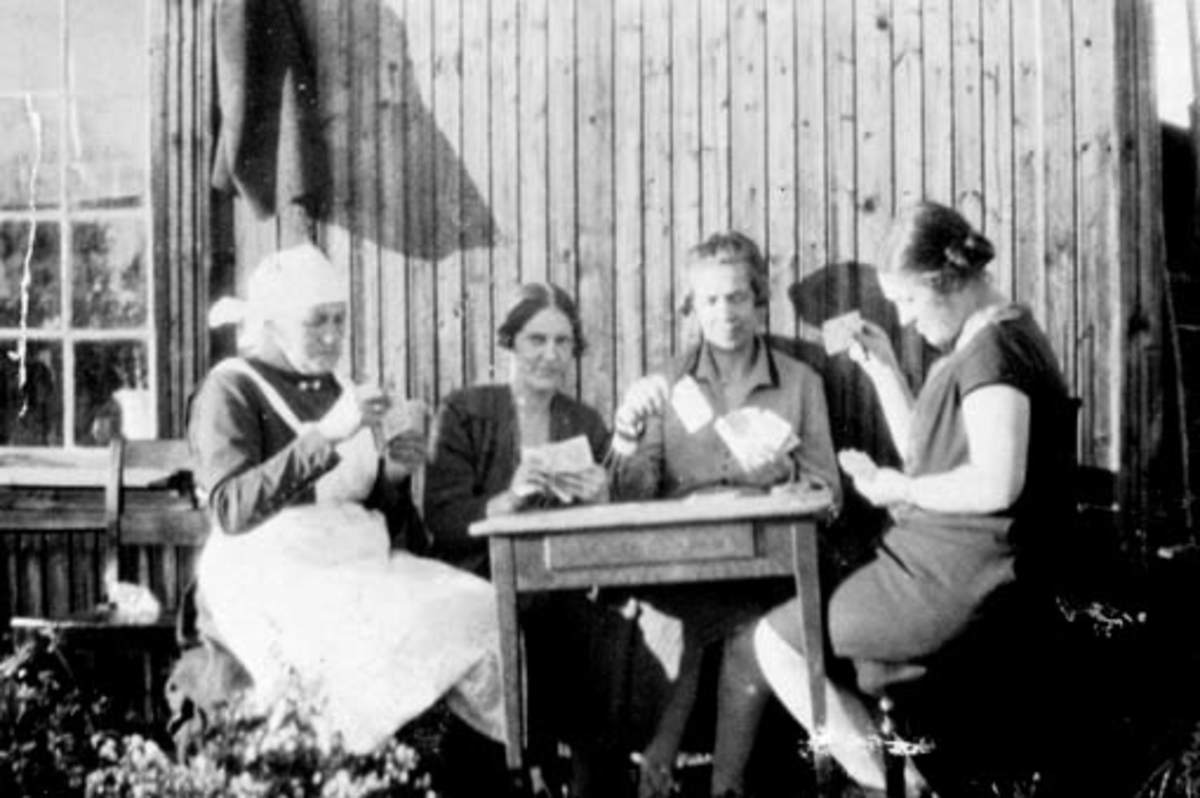 Anno Domkirkeodden, 4 damer spiller kort foran husmannsplassen Skredder-Rykop under Skapal, Ringsaker.