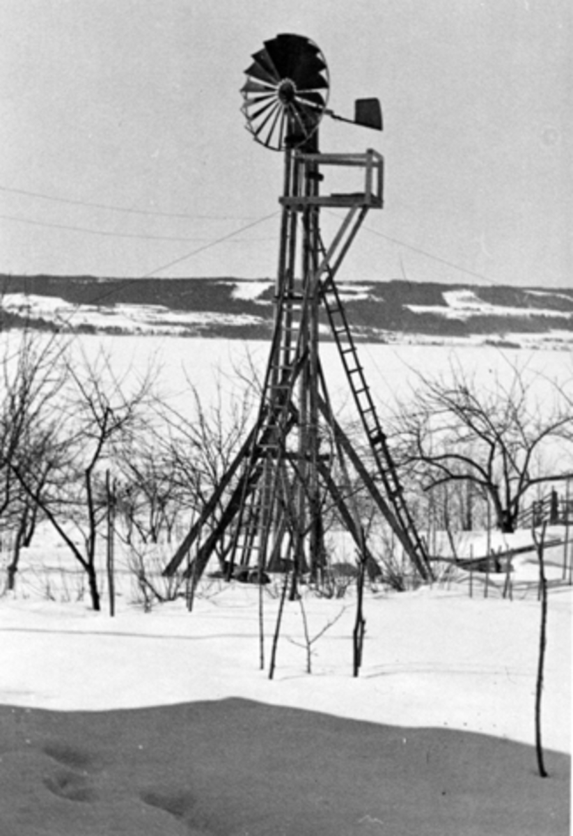 Anno Domkirkeodden, Vindmølle laget av snekkermester Hagbart Andreassen Lundstein som sto i hagen hans på Seilstad, Sandvoll, Nes. Vinter. Stedet var selvforsynt med strøm, når det var tilstrekkelig med vind.