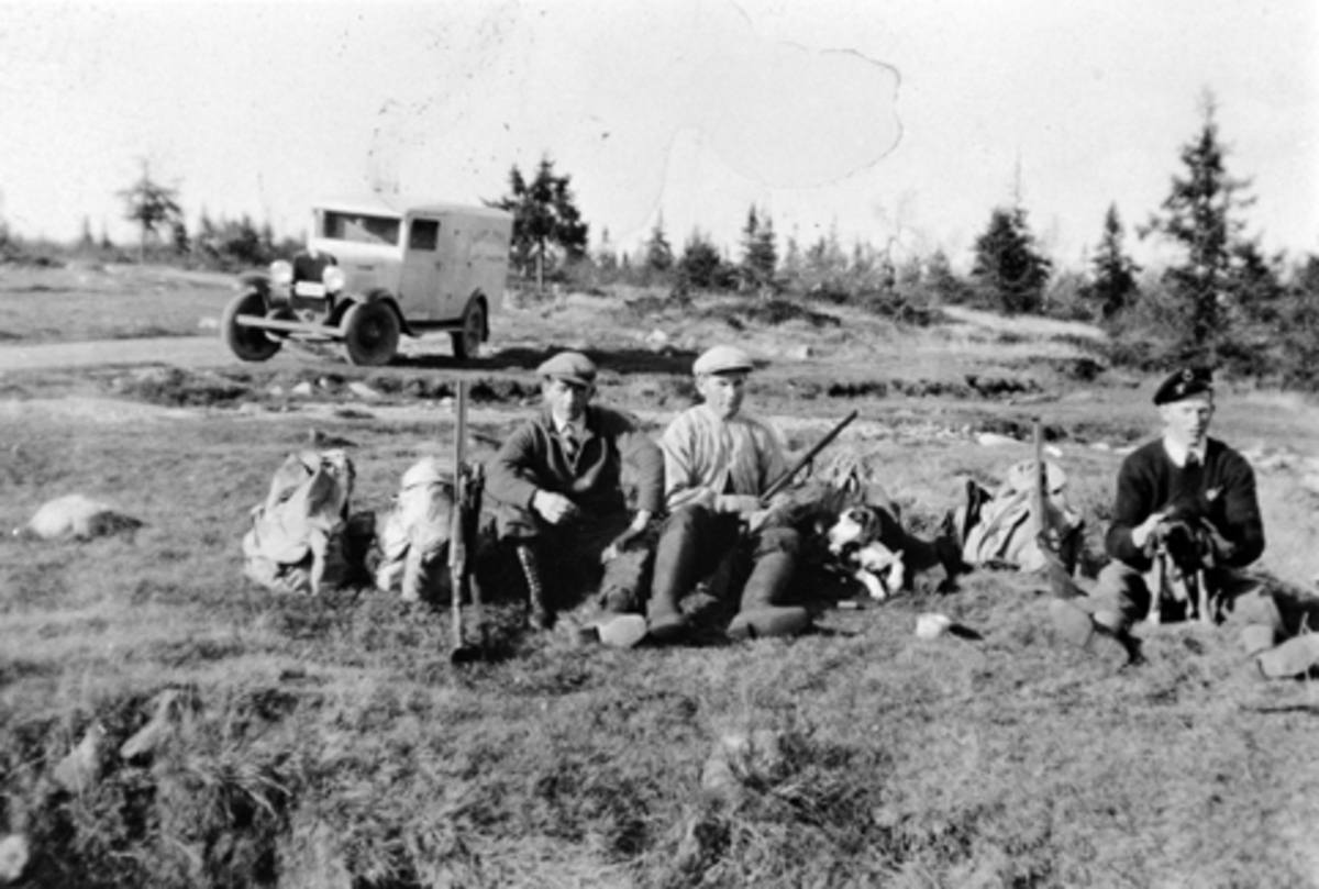 Anno Domkirkeodden, Gruppe jegere med hunder og gevær. Gjermund Barflo (slakter i Brumunddal), John Barflo, Ole Røset, bil i bakgrunnen, Furnes Almenning.