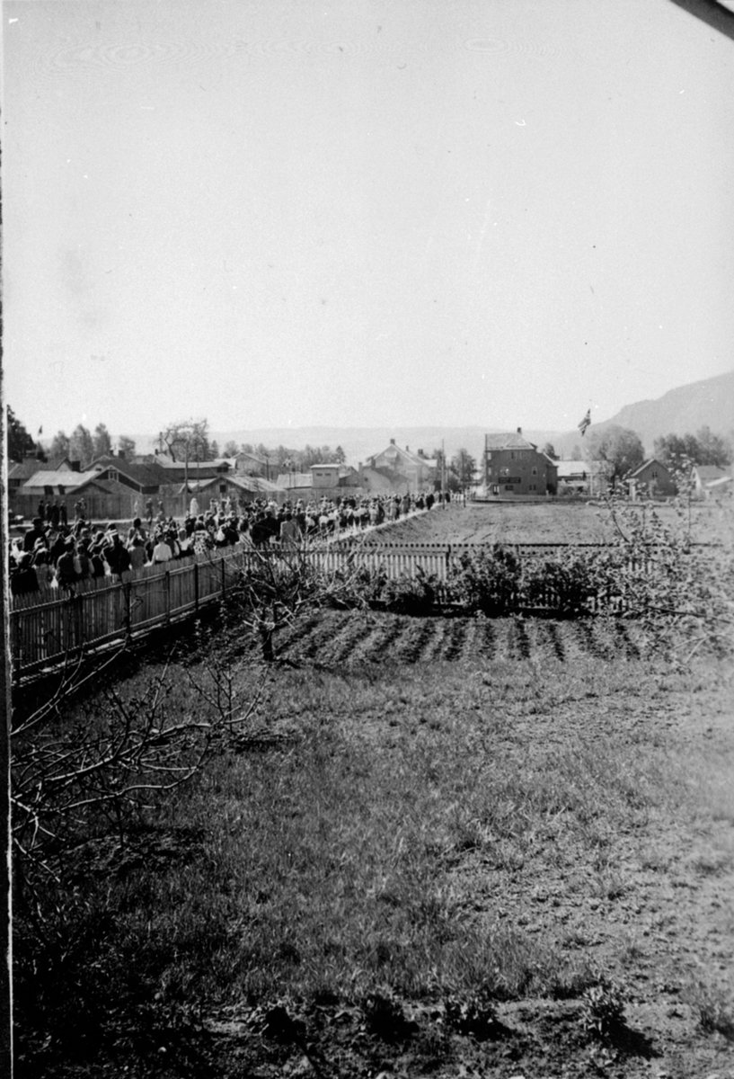 Anno Domkirkeodden, 17. mai 1938-1939. Brumunddal. Barnetoget på vei ned Nygata til Husebyparken. Bare hage og åker mellom Fjordgløtt og Ulven.