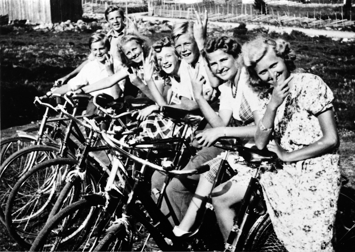 Anno Domkirkeodden, Ungdommer på sykkeltur under krigen, Sjusjøen, 1944. alle gjør v-tegn. Fra venstre er Leif Hornæss, Ole Solberg, ukjent, Solveig Hornæss, Arne Hornæss, Gerd Solberg, Agnes Solberg.