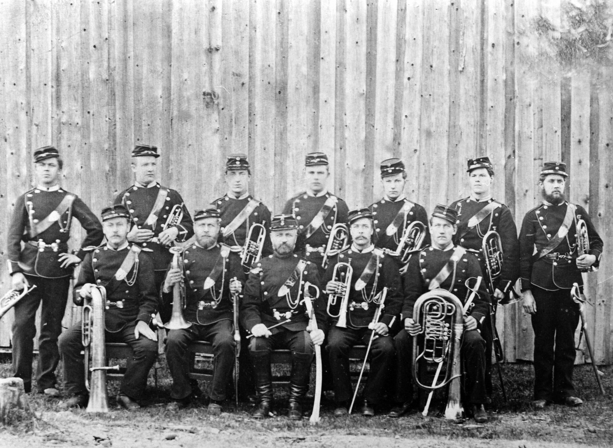 Anno Domkirkeodden, Tolv militærmusikere i uniform. Messingblåsere. Ringsagerske Eskadron ca. 1880. Foran fra venstre er Peter Nordby Toten, M. Syversen Toten, standartjunker J.O.Lier Hamar, skomaker Østberg Ringsaker, Laurits Kihle Toten. Bak fra venstre er Ludvig Larsen Nes, Martin Norseng Hamar, Hagbart Hollo Hamar…