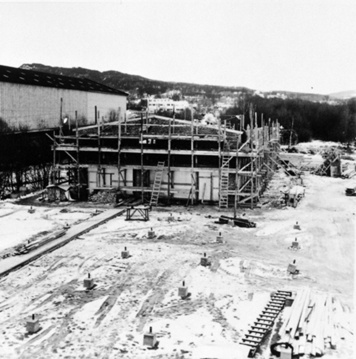 Anno Domkirkeodden, Berger Langmoen A/S, Brumunddal. Ny parkettfabrikk bygges på Husebyenga. Reisverk og stillaser.