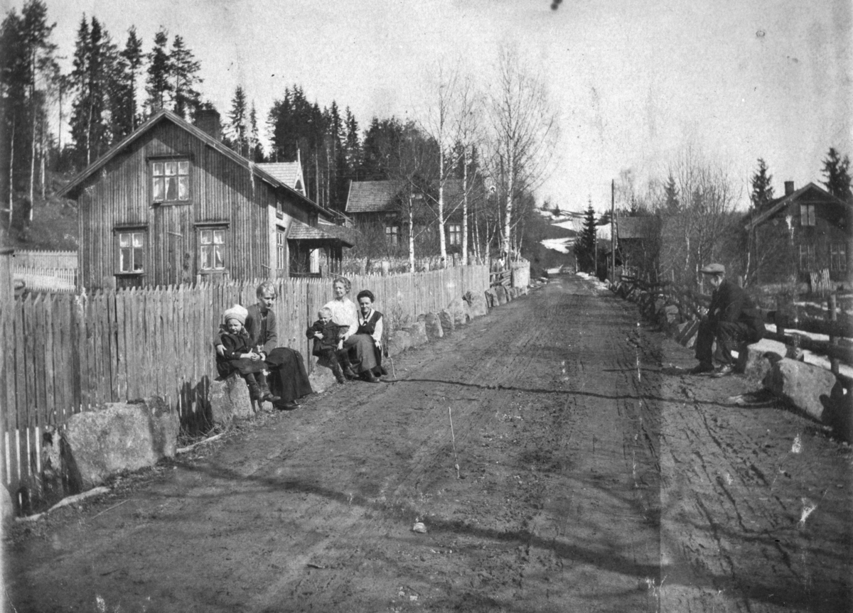 Ukjent, Åsmarkvegen ca. 1928. Huset t. v. er Engstad, bygget 1911 av Johannes Svestuen. Bak Engstad ligger Sollien bygget rett etter 1900 av snekker Ole Johansen, deretter Skogheim. Her bodde Mathias og Syverine Skogheim. T. h Elverhøy. Her bodde Ingeborg f. 1876 og Ingvald f. 1872 Elverhøy. Stabbesteiner.