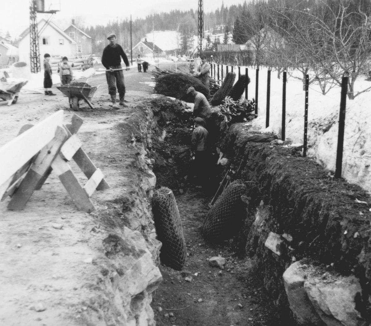 Ukjent, Pinnerudvegen i Moelv. Graving og legging av ny vann og kloakkledning ca. 1952-1955. Graving for hånd, trillebår, spader. Grøft.