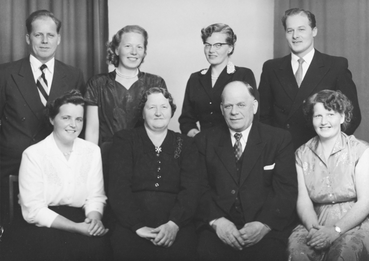 Normann Fotoatelier, Familiebilde Nyhagen ca. 1955. Foran f. v. Ingrid Nyhagen g. Bekkevold, Inga Nyhagen, Alfred Nyhagen, Ruth Nyhagen. Bak f. v. Jens Nyhagen, Sara Nyhagen g. Negård, Synnøve Nyhagen g. Evensen og Arne Nyhagen.