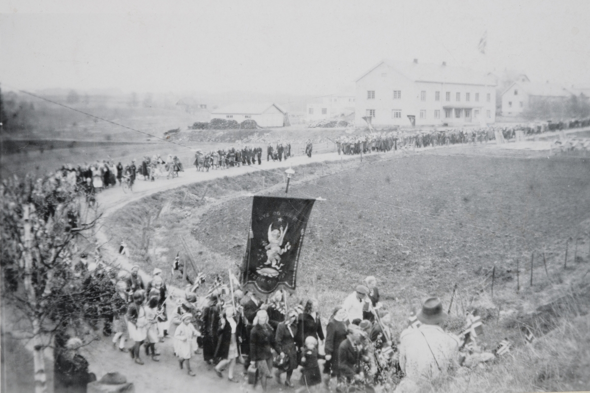 Anno Domkirkeodden, 17. mai-tog, Løten. Bergsbakken, Stasjonsvegen. Bøndernes hus i bakgrunnen. Bildet tatt fra jernbaneovergangen.