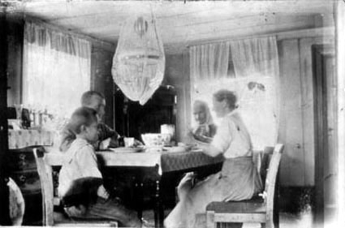 Anno Domkirkeodden, INTERIØR: STUE, SMESTAD BRUK UNDER RYEN, FAMILE RUNDT SPISEBORDET, OLAV SMESTAD, PETTER SMEDSTAD, INGE SMEDSTAD, MATHEA SMEDSTAD