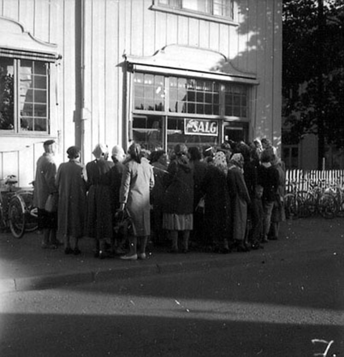 Anno Domkirkeodden, EKSTERIØR: AGNES GODAGER FORRETNING, UTSALG, MYE FOLK I KØ, SOLBRÅ I STORGATA