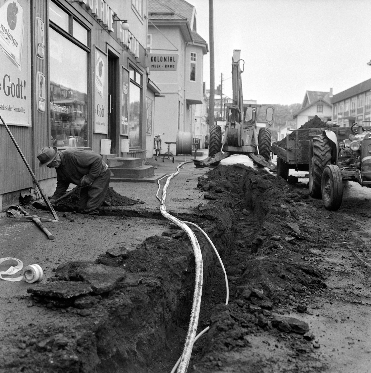Anno Domkirkeodden, LEGGING AV KABEL I STANGEBYEN UTENFOR BJ. FINSTADS FORRETNING: MELLEM I STORGATA, GRØFT, GRAVEMASKIN OG TRAKTOR TIL HENTING AV MASSE