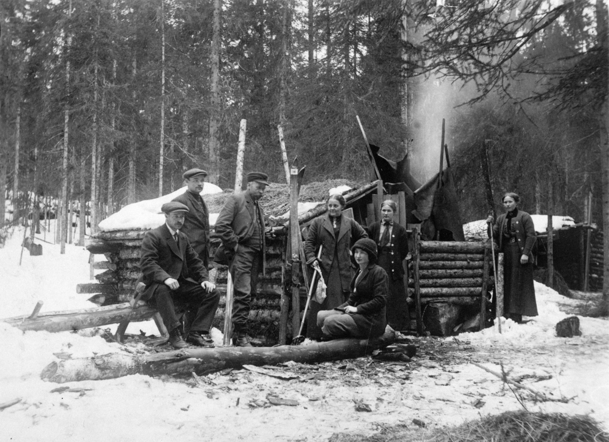 Normann Helger, TØMMERKOIE, MIDDAGSBERGKOIA, GRUPPE: 7 PERSONER FORAN, VINTER, ROMEDAL ALLMENNING,