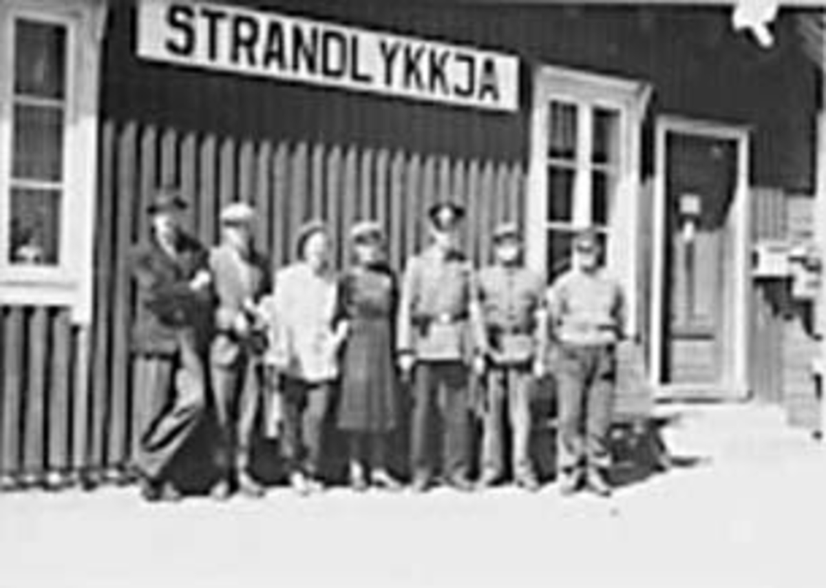 Anno Domkirkeodden, GRUPPE: 7, FLYKTNINGEHJELPEN 1940 - 45, STRANDLYKKJA STASJONSBYGNING BAK, FRA VENSTRE: ARNE SAKARIASSEN, ALEKSANDER KRISTOFFERSEN. KVINNEN I MIDTEN ER MARIE WESTBY, BANEVOKTER HJALMAR WESTBY TIL HØYRE.