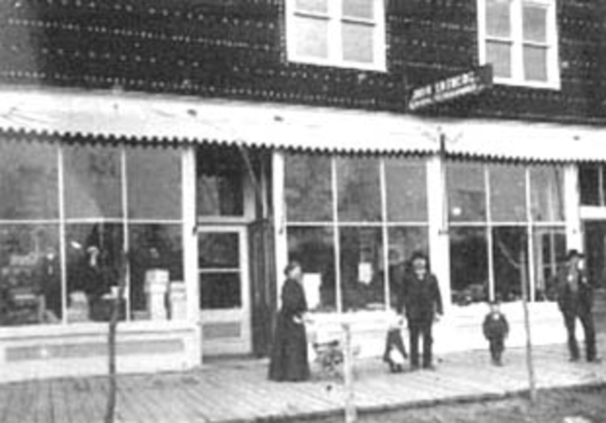 Normann Helger, EKSTERIØR: BUTIKK, JOHN EKEBERG FRA TANGEN, TREFORTAU, FOLK, USA, (STANGE)