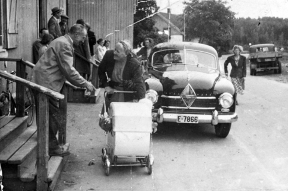 Anno Domkirkeodden, UTENFOR LUNDBYBUTIKKEN I STANGE. BILDET ER TATT 17. JUNI F. V. PÅ TRAPPA INGVALD LUNDBY, HILDA HAGEN MED BARNEVOGN. T. H. FOR BILEN MARTHA MOEN, T. V. FOR BILEN INGRID ÅSEN. BAKRE TRAPP MED LUE? BAKER EVENSEN SOM JOBBET HOS LUNDBY. PERSONBIL E-7866. Utenfor Lundbybutikken høsten 1952. Bilen en Borg…