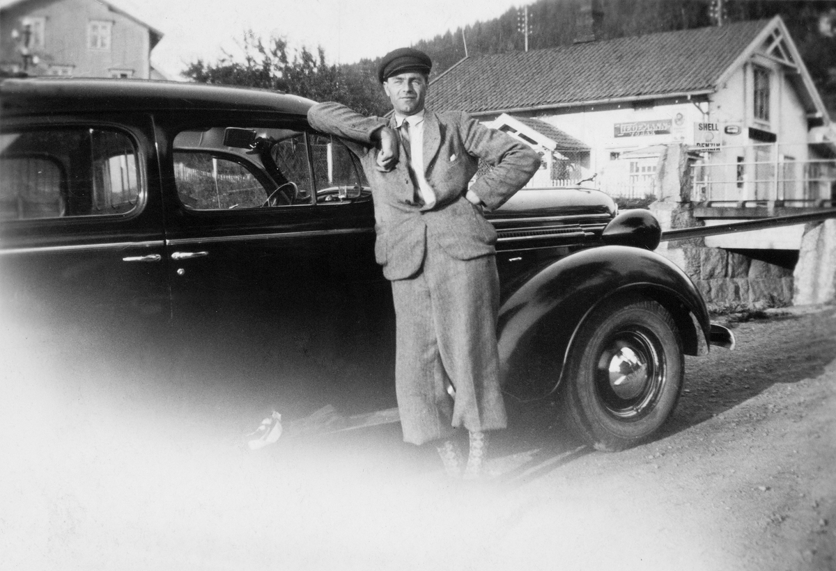 Anno Domkirkeodden, Juel (Juul) Nordnes, drosjebil, Taxi, Espa Stasjon. Drosjen er en Dodge 7-seter, årsmodell 1937-38, montert på Strømmens Værksted.