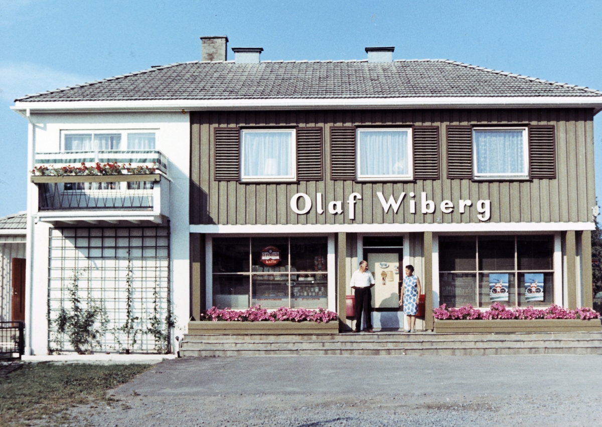 Ukjent, Hjørnegård, Ottestad. Kjøpmann Olaf Wiberg i Ottestadkrysset. Kolonial.. Olaf og Thora utenfor butikkinngangen midt på 1960-tallet. Flere opplysninger se boka "Handelssteder i Stange" skrevet av Jan Arne Berg, utgitt av Stange Historielag 2012