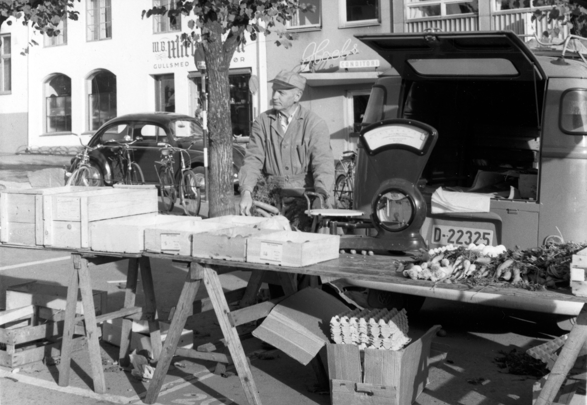 Ukjent, Torghandler Erik Torgerhagen, f. 1902, Stortorget, Hamar. 1960-tallet. Salg av grønnsaker, egg. Flere opplysninger se boka "Handelsforretninger i Stangeby`n med omegn" skrevet av Jan Arne Berg, utgitt av Stange Historielag 2013.