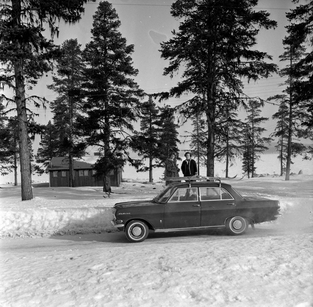 Adolf Skjegstad, Opel Rekord modell A 1963-65. (Rekord B 1966 var identisk men hadde runde baklykter). Skistativ, to ukjente kvinner. med ski på taket.