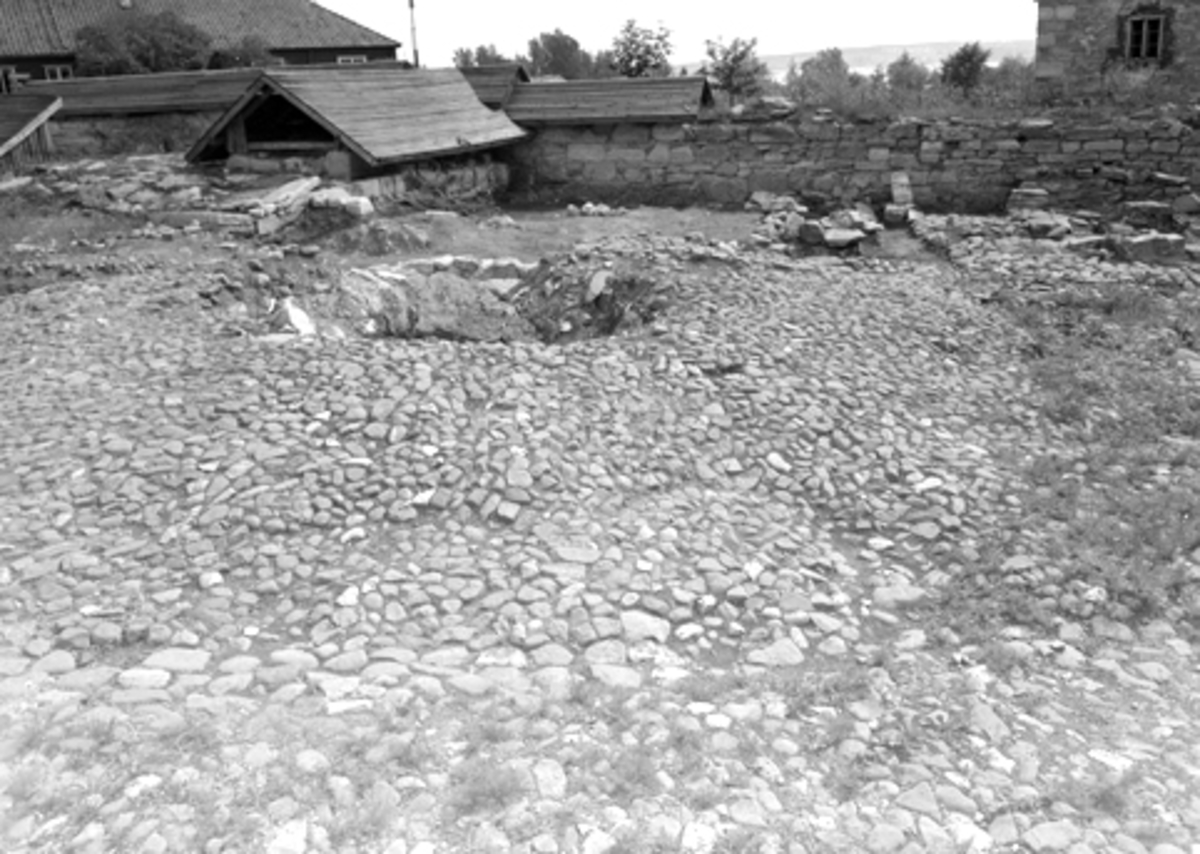 Normann Fotoatelier, Arkeologiske undersøkelser i Hamar bispegård, Domkirkeodden, Hamar 1956. Brolegging i bispegårdens midtparti og rester av brønnen.