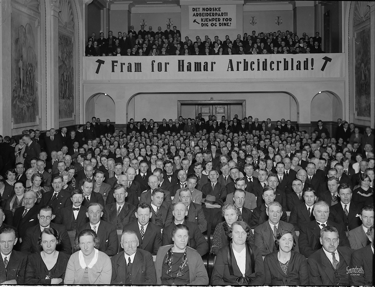 Christian Grundseth, HAMAR ARBEIDERBLAD FEIRER TI ÅR. FESTMØTE 1935 I FESTIVITETEN. FILMFRAMVISER MIDT I SALEN. TEKST FORAN GALLERI: FRAM FOR HAMAR ARBEIDERBLAD. MYE FOLK. Partiformann i Arbeiderpartiet Oscar Torp og statsråd Fredrik Monsen holdt festtalene. Det ble vist film om arbeiderbevegelsens fremmarsj der en del…
