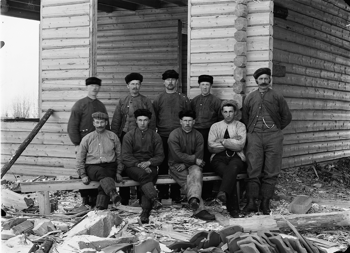 Martin Finborud, Snekkerlaget til Martin Dæhlin (1858-1937) fra Helgøya i Ringsaker. Dæhlin står ytterst til høyre. Ved siden av ham står Karl Slåtten sittende til venstre er Hilmar Solbakken f.1885, de andre er ukjent. Lafting av hus, antagelig Årengen skole på Nes, 1901.