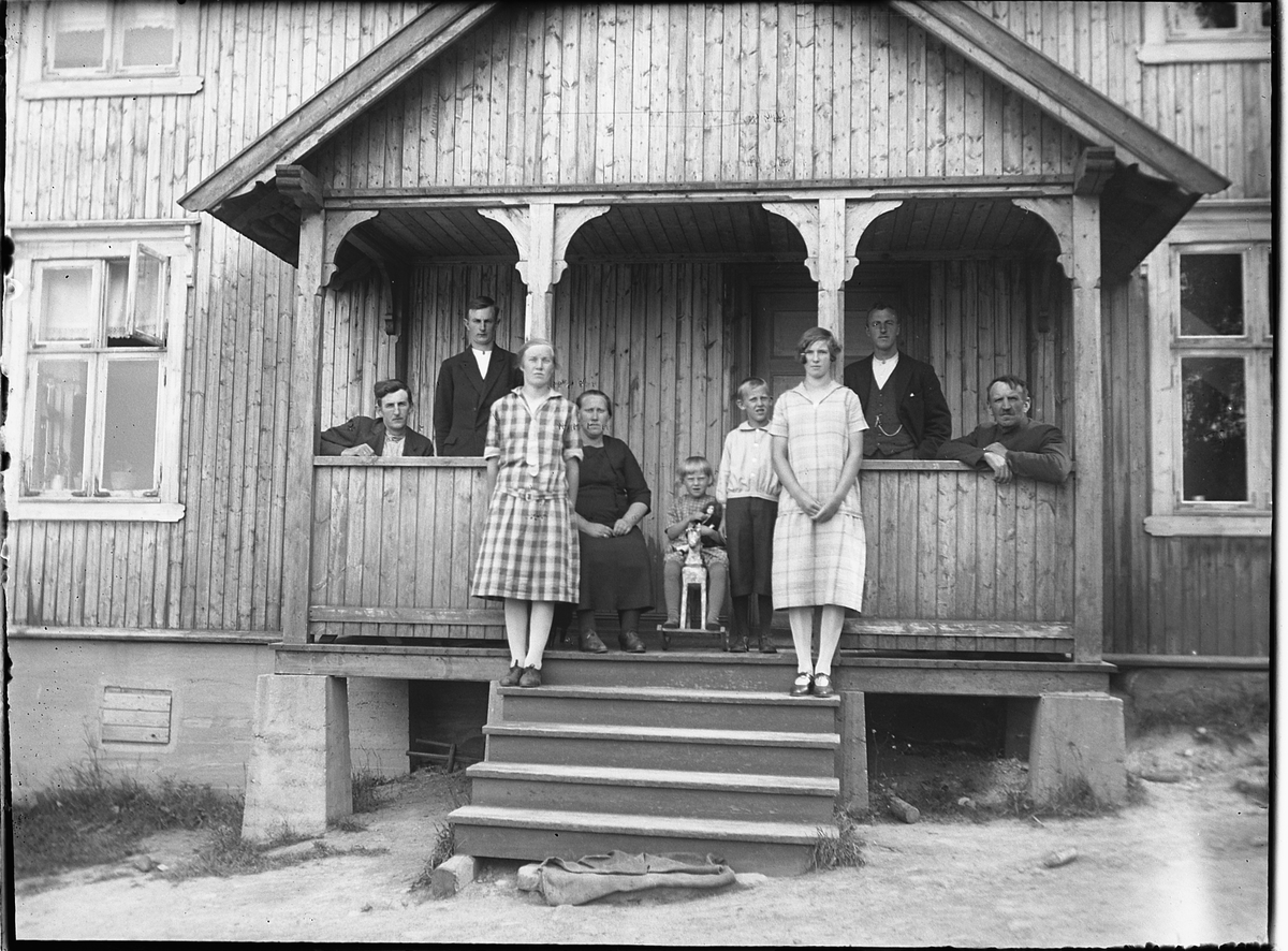 Ole M Martinsen, Ukjent gruppe, familie på trapp på ukjent sted. Jente med dokke på en gyngehest.