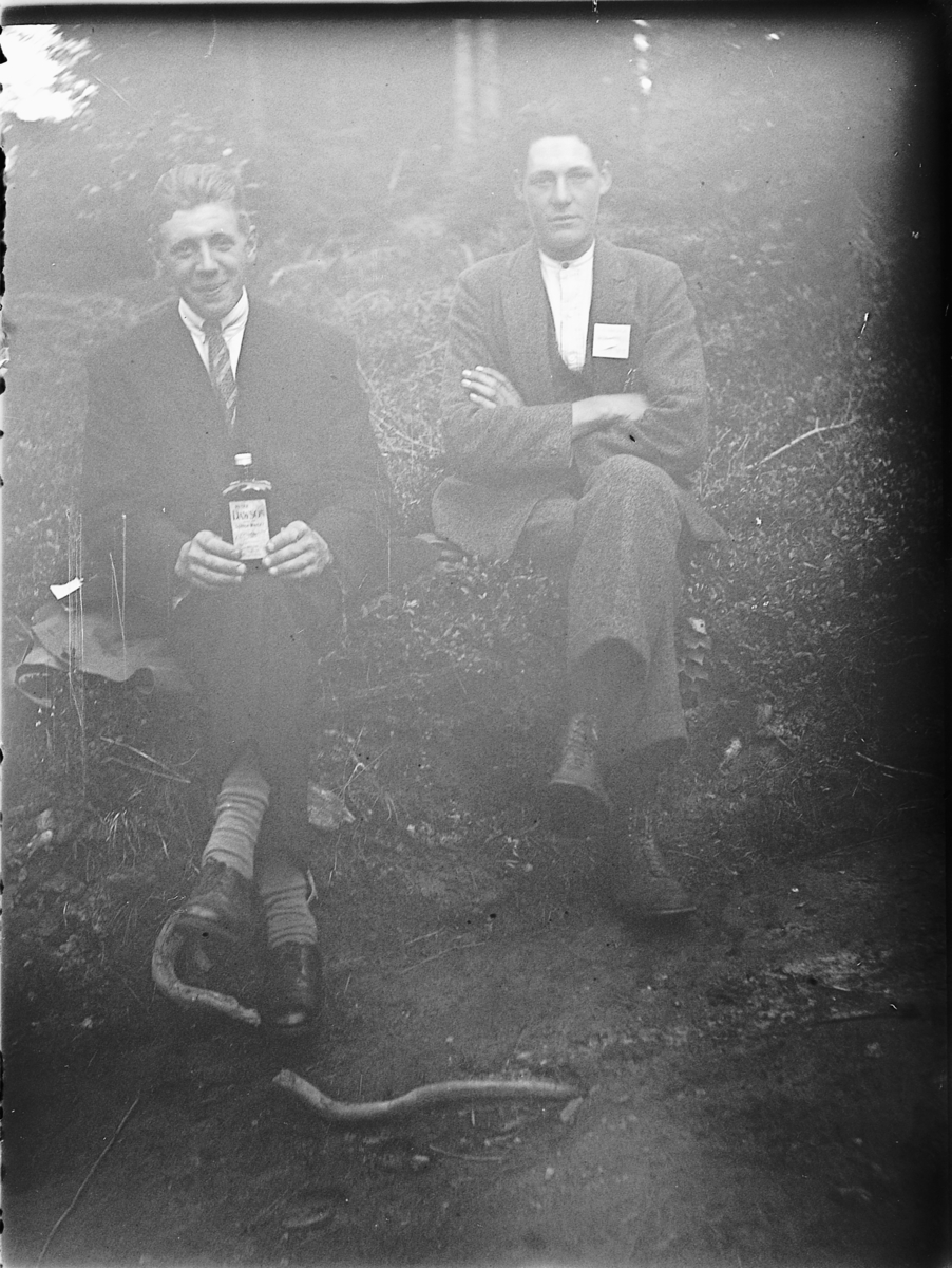 Ole M Martinsen, Eksteriør, skog. To ukjente menn. Den ene holder en flaske sprit?