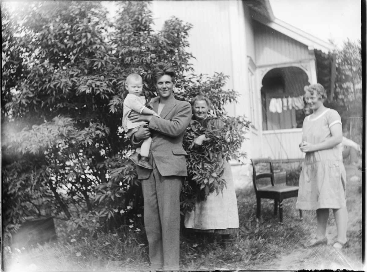 Ole M Martinsen, Eksteriør, hage. Fire ukjente personer, familie. Mann med et barn på armen.