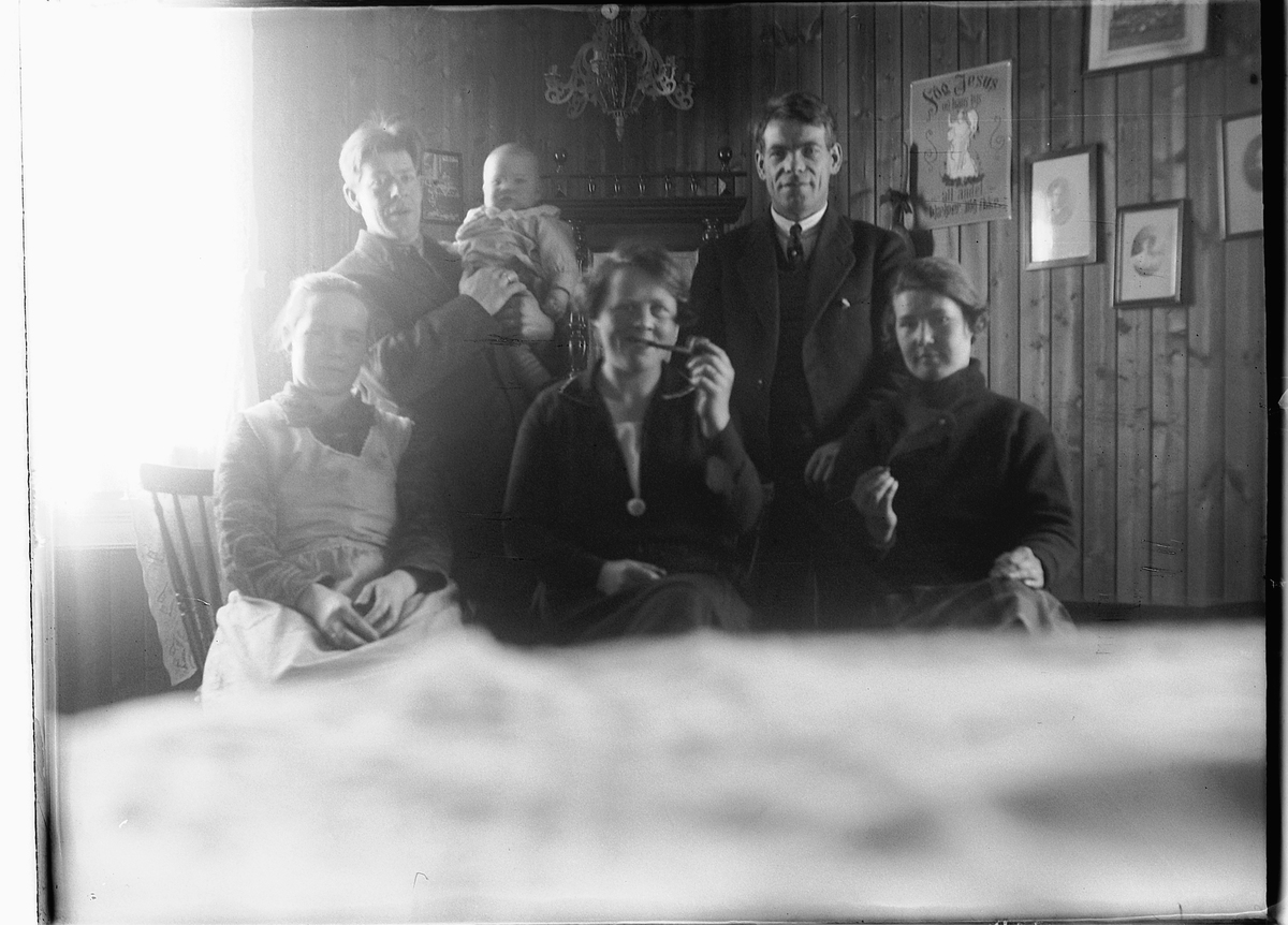 Ole M Martinsen, Gr. 6. Familiebilde tatt med sjølutløser. Tre kvinner sitter, to menn bak, barn på armen. Kvinnen røyker pipe.