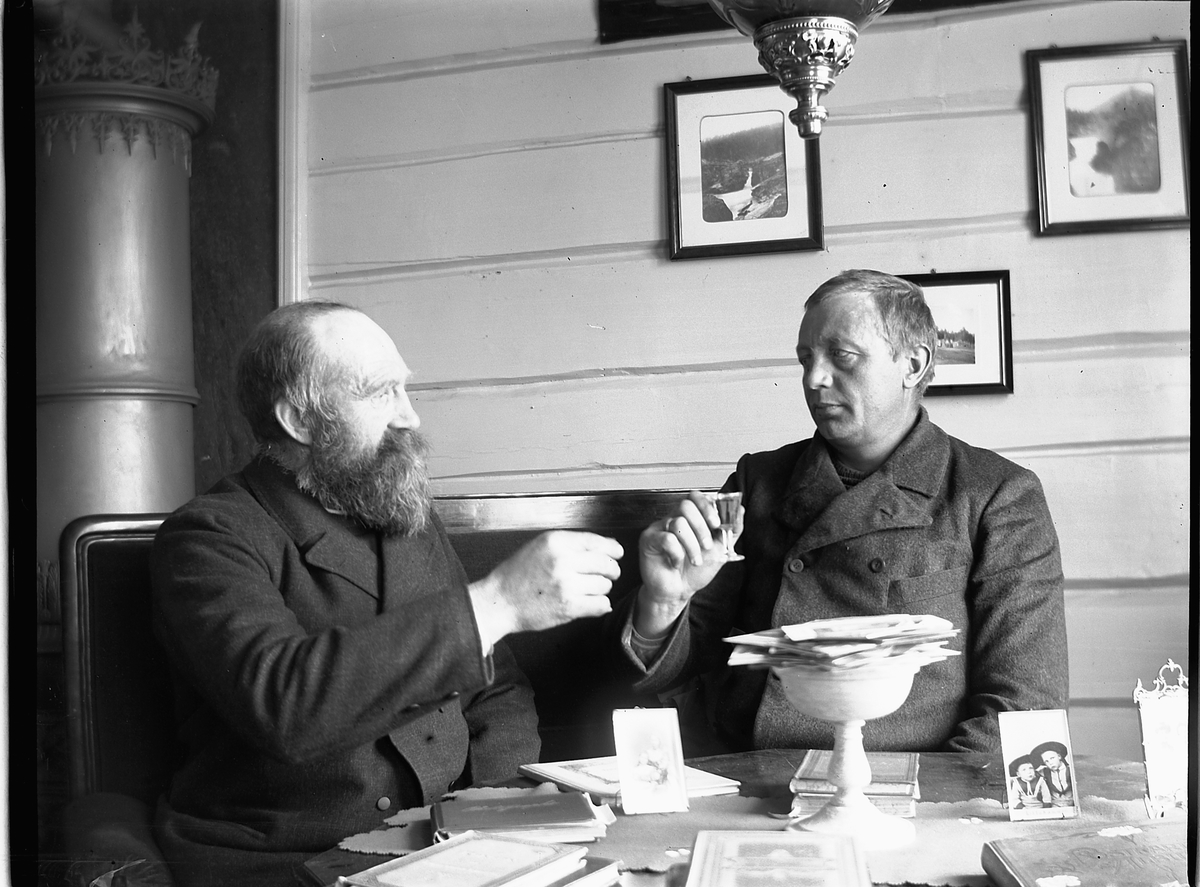 Ole Hansen Løken, TO MENN UTBRINGER SKÅL, F. V. ANTON FJELSTAD OG UKJENT.