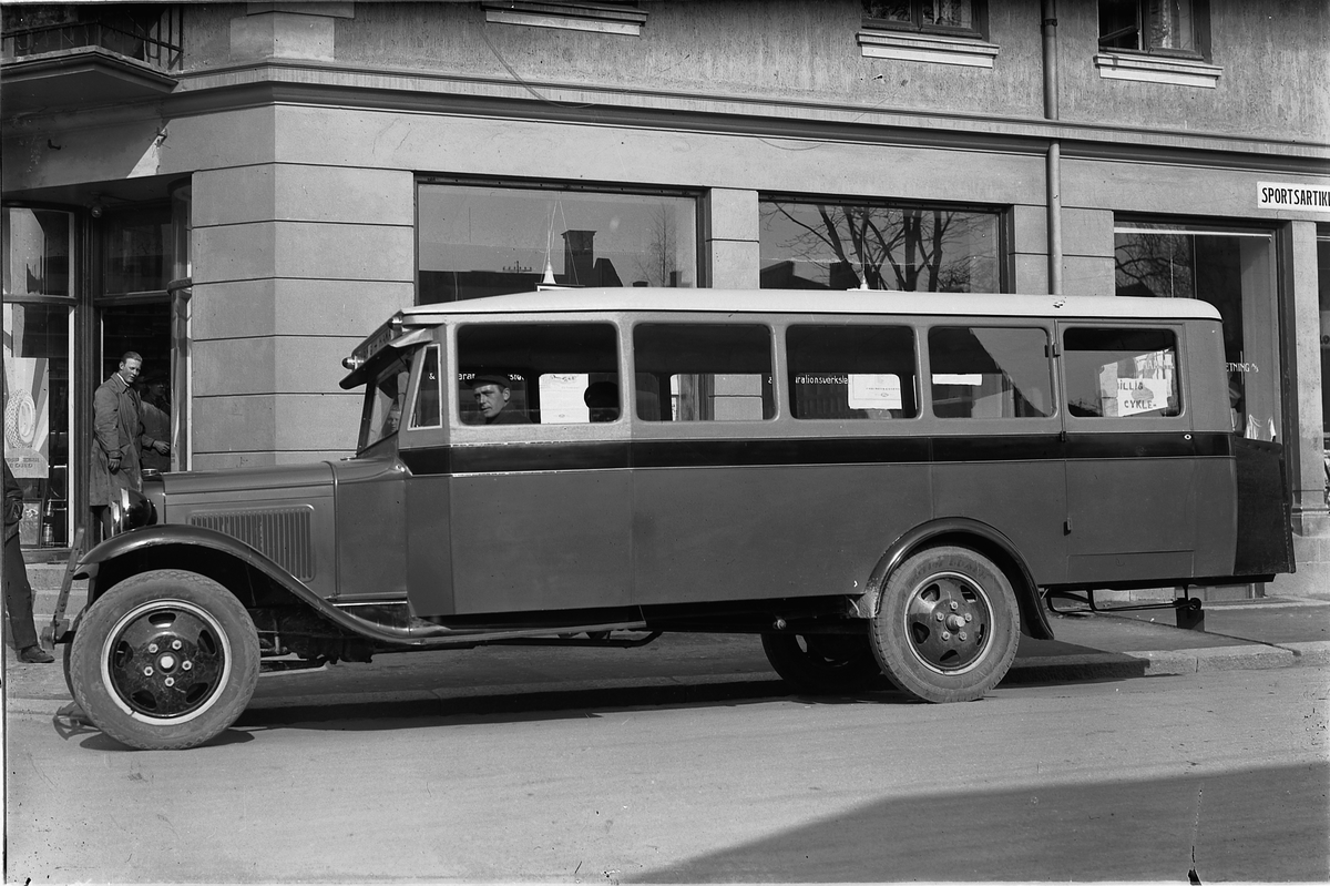 Oscar Løberg, BUSS, FORD AA, ARVID SANDBAKKEN BAK RATTET, BILEN GIKK I RUTE MELLOM HAMAR OG BYFLATEN I VELDRE. PÅ TRAPPA EKSPEDITØR SIGURD HANSEN VED OPPLANDSKE AUTO i Torggata, HAMAR, 1928.