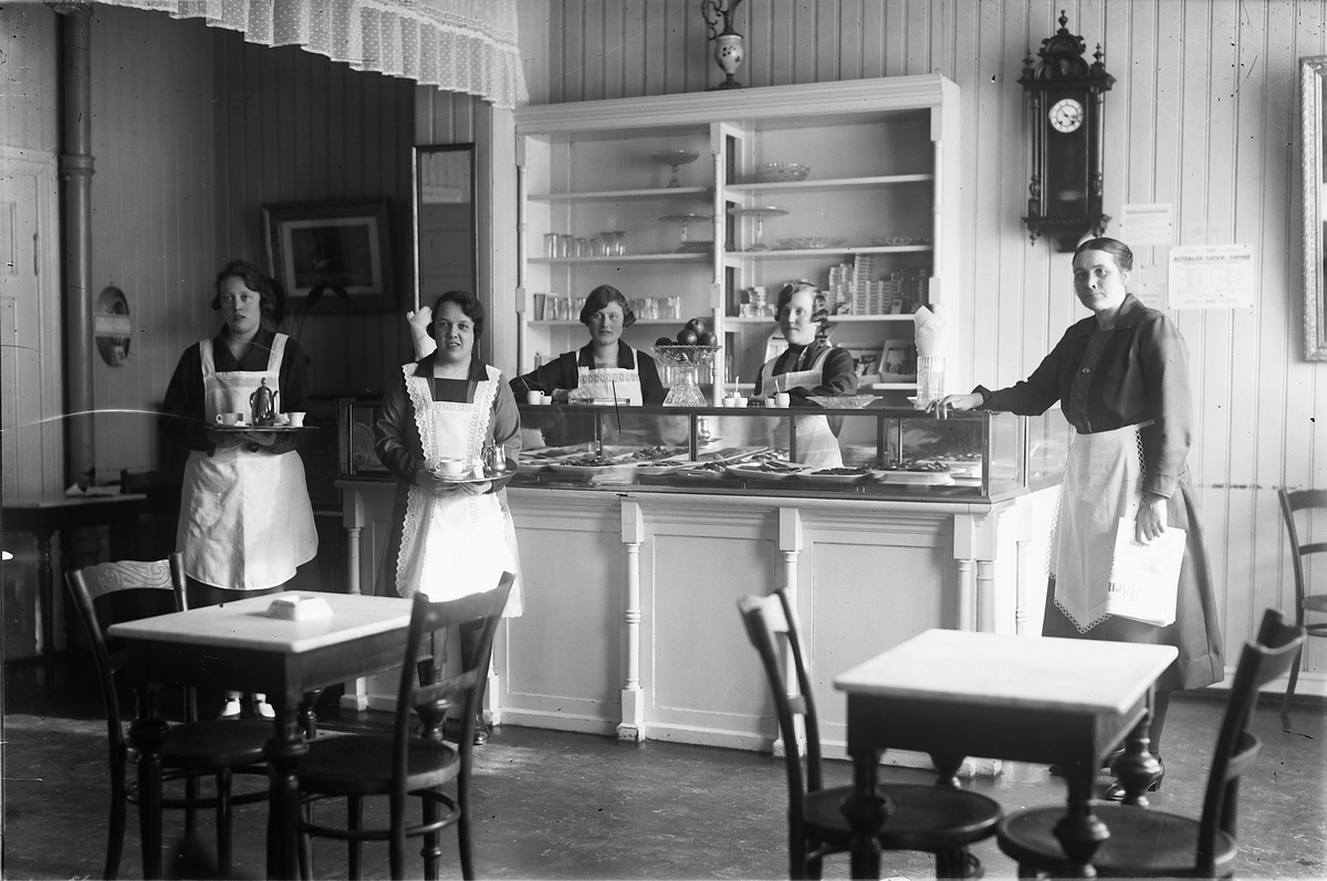 Oscar Løberg, ILSENG CAFÉ, TORGGATA 3, HAMAR, INTERIØR, 1922-23. Kaféen holdt opprinnelig til i snekker M. Olsens gård. Ragna (senere gift Øvergård) og Marie Ilseng drev stedet. Fru Svenkerud overtok driften i 1933. FH. BESTYRERINNA, UKJENT, FRK. OPPHUS, UKJENT, UKJENT.