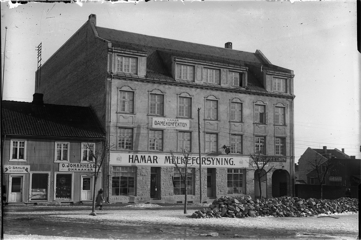 Oscar Løberg, HAMAR MELKEFORSYNINGSGÅRD I VANGSVEGEN, HAMAR, NYBYGD, DEN FORRIGE BRANT NED I 1917, T. V. URMAKEREN. FOTOGRAF LØBERG HOLDT TIL TIL VENSTRE I GÅRDEN.