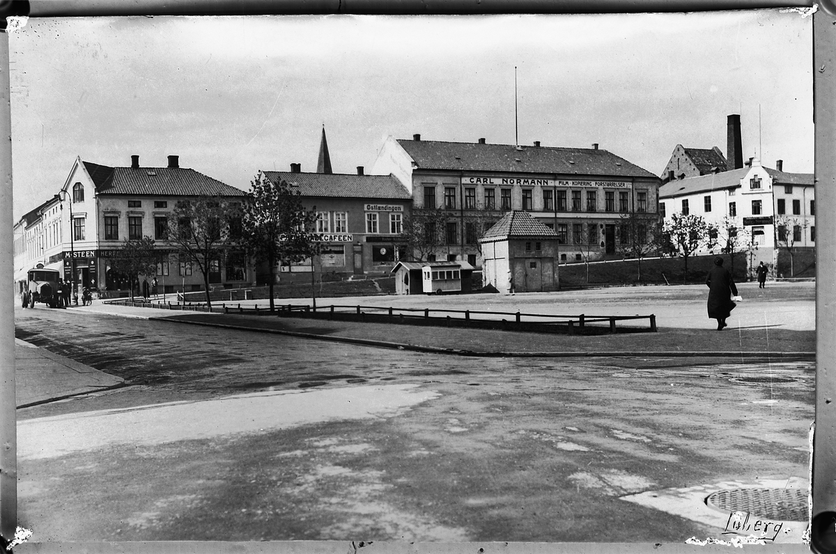 Oscar Løberg, ØSTRE TORG, HAMAR. FV. M. STEEN, ØSTLENDINGEN MED PROMENADEKAFÉEN, SPIRET PÅ METODISTKIRKA, CARL NORMANN, ARBEIDERFORENINGA, BAK SKIMTES "DESTILLASJONEN".
