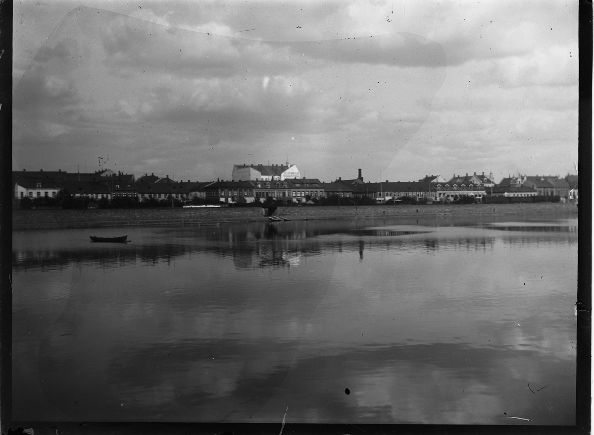 Johs. (Johannes) Johannessen, Hamarbukta med jernbanefyllinga. I bakgrunnen Strandgategårdene og forretningsgården til G. L. Granerud (ferdig i 1898). Mjøsa.