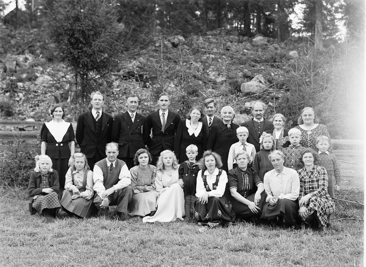 Håkon Prestkværn, Familiegruppe, konfirmasjon. Foto tatt 5. oktober 1947 ved konfirmasjonen til Anne Karoline Langgård på Nedre Langgård i Næroset. Personene på bildet: Bak fra venstre: Laura Sagstuen (født Langgård), Hans Langgård, Gunnar Elvsvebakken, Sigvald Langgård, Sigrid Borgersen, Olaf Bjerkevold, Birgitte B…