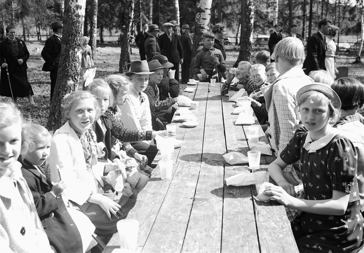 Håkon Prestkværn, Ukjent gruppe barn sitter ved et langbord ute.