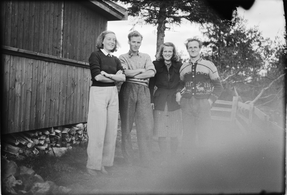 Håkon Prestkværn, To kvinner og to menn utenfor hus.