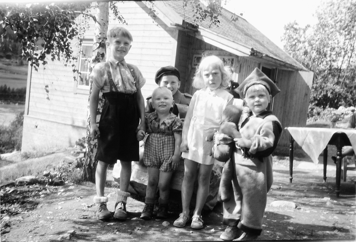 Håkon Prestkværn, Gruppe 5 personer. Barn foran et hus. Gutt med lue sittende bak er Ole Christian Prestekværn, jente lengst til høyre er Brita Prestkværn, resten er ukjente.