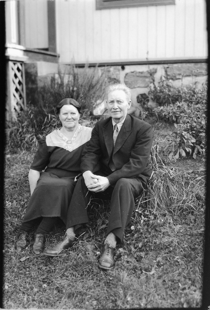 Håkon Prestkværn, Eldre kvinne og mann ved husveggen.