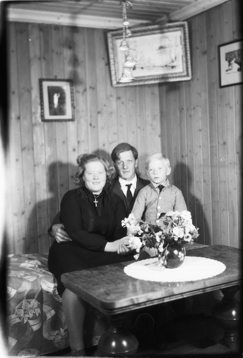Håkon Prestkværn, Interiør, stue. Familien Aamodt i en sofa.