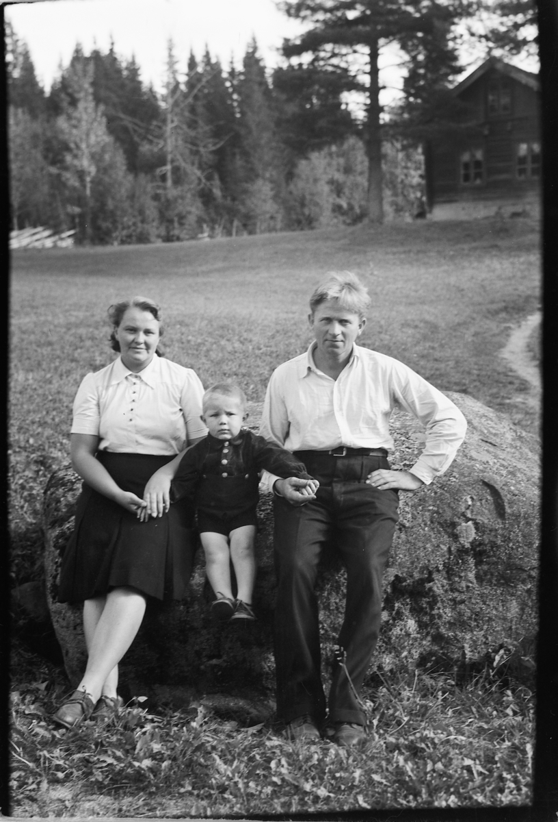 Håkon Prestkværn, Ukjent kvinne og mann med et barn mellom seg sitter på en stein.