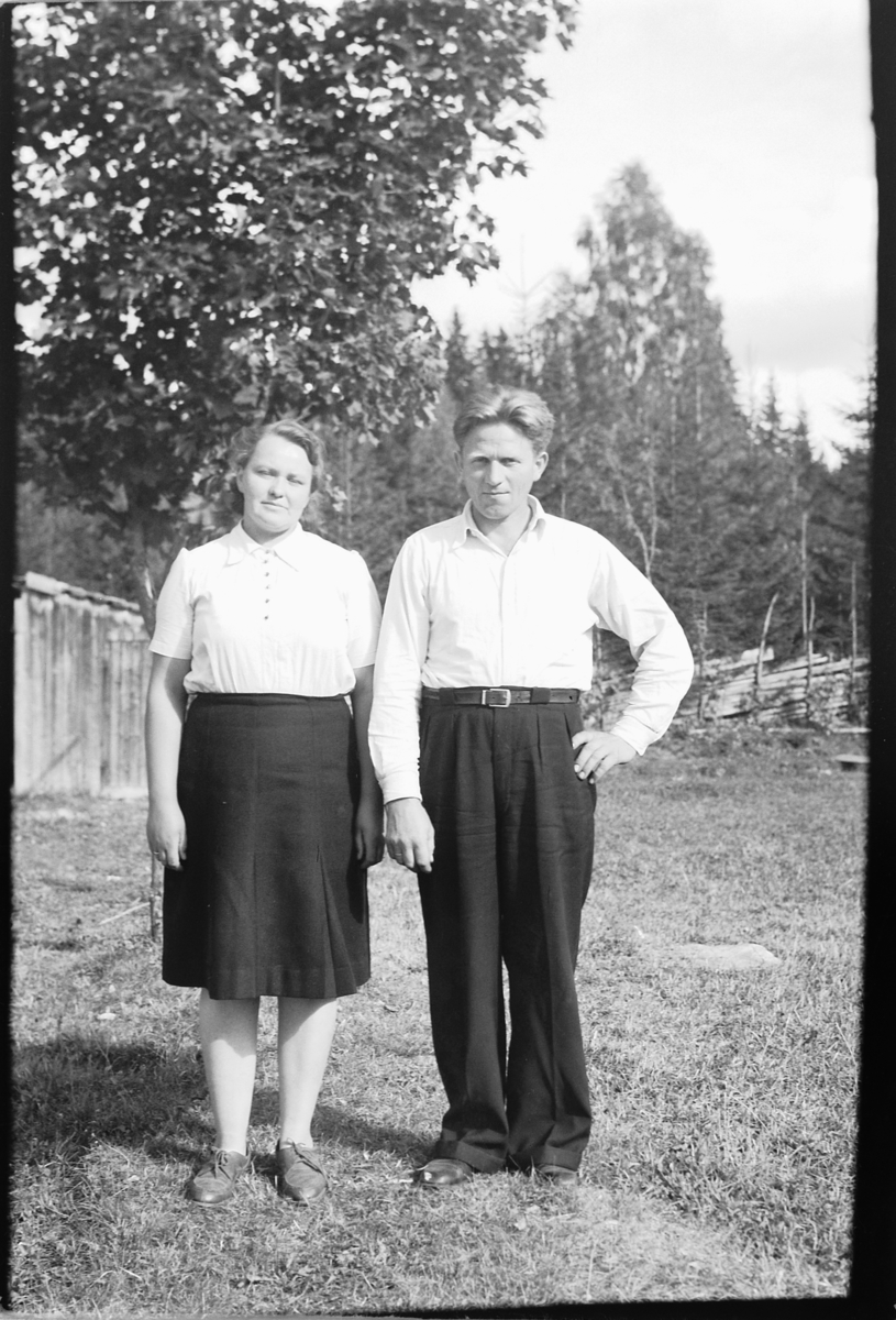 Håkon Prestkværn, Ukjent kvinne og mann. Skog og skigard i bakgrunnen.